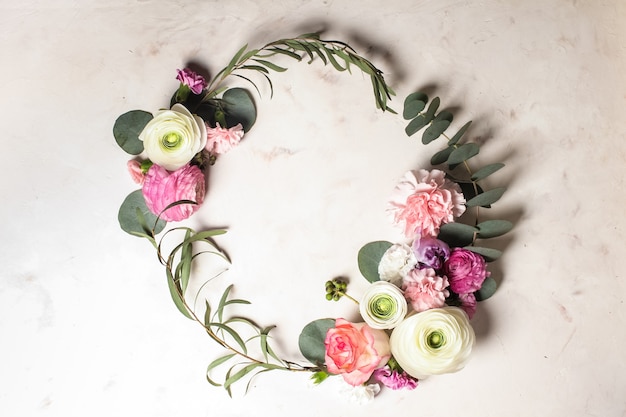 Photo cadre rond floral avec branches et feuilles d'eucalyptus, fleurs plates, vue de dessus avec espace de copie