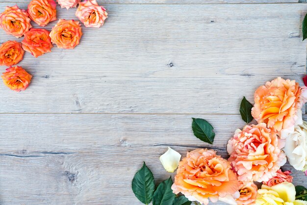 Cadre de roses sur fond en bois gris.