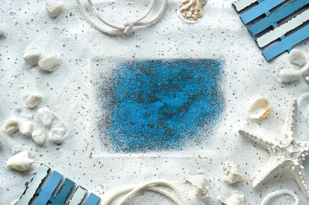 Cadre de sable, coquillages, étoiles de mer, cordon. Monochromatique blanc cassé, plat bleu turquoise, espace de copie.