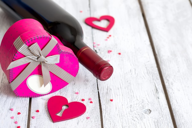 Cadre de la Saint-Valentin avec bouteille de vin rouge et coeur présent