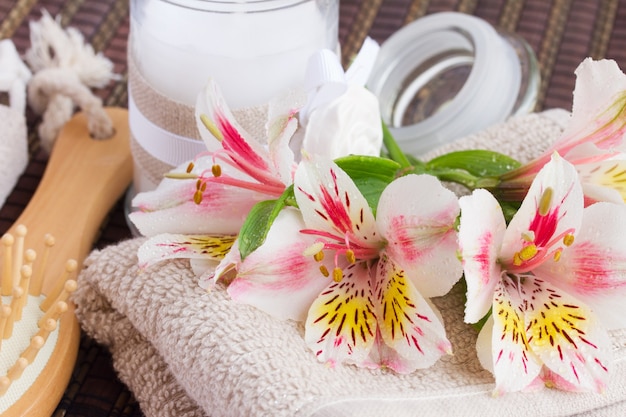Cadre spa avec des fleurs fraîches d'alstroemeria, des serviettes et une bougie aromatique