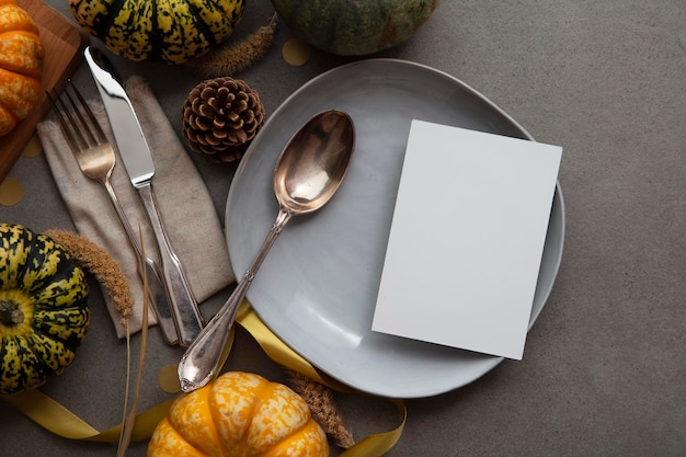 Cadre de table d'action de grâces d'automne avec carte d'invitation de menu vierge entourée de citrouilles festives