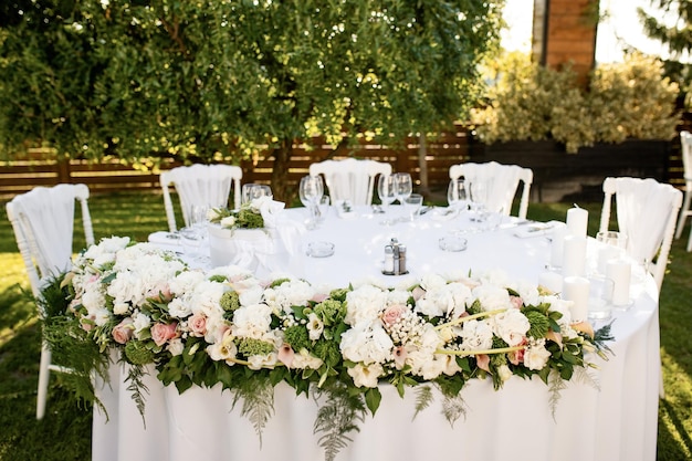 Cadre de table élégant avec arrangement floral à la réception de mariage en plein air.