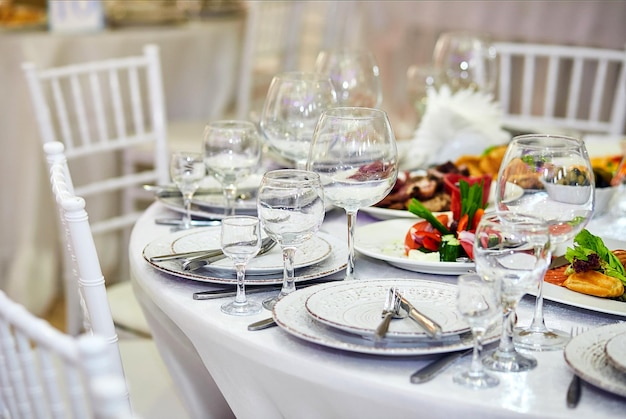 Cadre de table élégant dans des tons beiges blancs prêt pour l'arrivée des invités Beaux plats à l'intérieur du restaurant