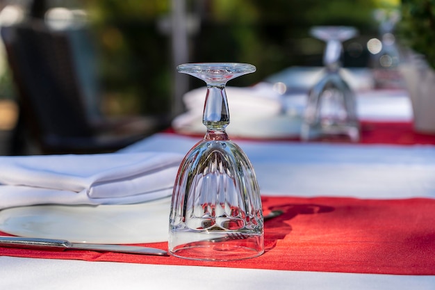 Cadre de table élégant avec fourchette couteau verre à vin assiette blanche et serviette rouge au restaurant Belle table à manger avec argenterie arrangée et serviettes pour le dîner