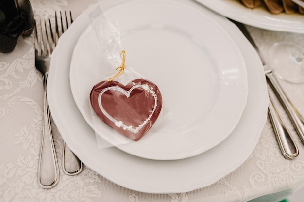 Cadre de table de fête pour la Saint-Valentin avec un couteau à fourchette et un coeur sur une table en bois blanche Table de dîner romantique Concept d'amour pour la coutellerie de mariage de la Saint-Valentin Espace de copie vue de dessus