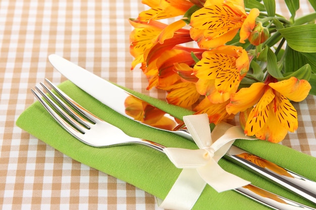 Cadre de table à manger de fête avec des fleurs sur fond quadrillé