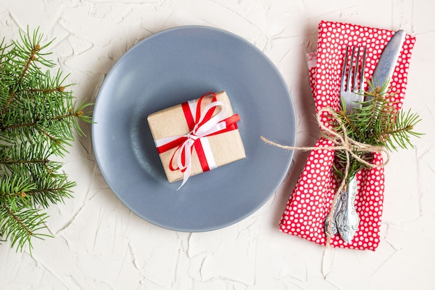 Cadre de table de Noël avec cadeau sur une plaque sur le tableau blanc. Vue de dessus du concept de Noël