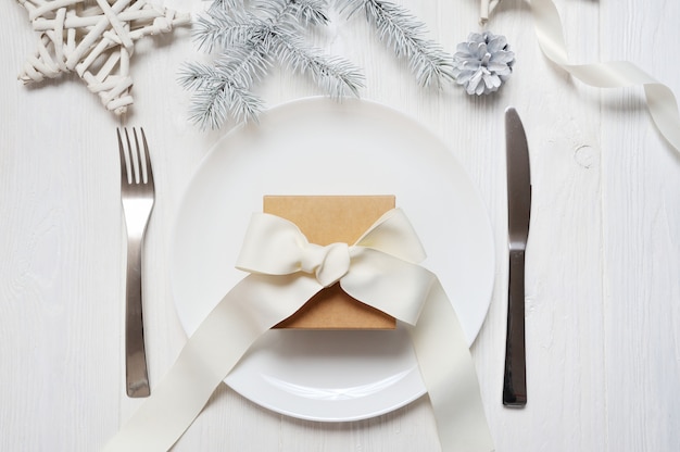 Cadre de table de Noël avec un cadeau vintage sur une table en bois blanc