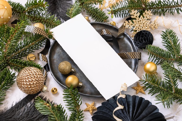 Cadre de table de Noël noir et doré avec ornements et branches de sapin Maquette de carte de menu