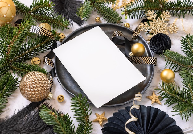 Cadre de table de Noël noir et doré avec ornements et branches de sapin Maquette de carte de menu