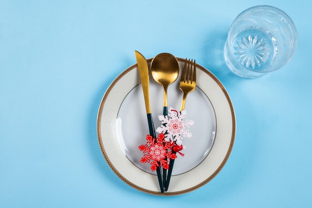 Cadre de table de Noël avec vaisselle moderne et décorations sur fond bleu Vue de dessus Couvert du Nouvel An Vaisselle de Noël Couverts de Noël Couverts de dîner de Noël avec décor