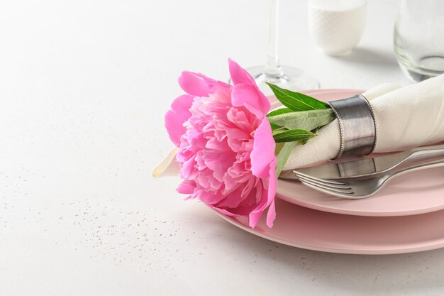 Cadre de table romantique de printemps avec des fleurs de pivoine rose sur un tableau blanc. Fermer.