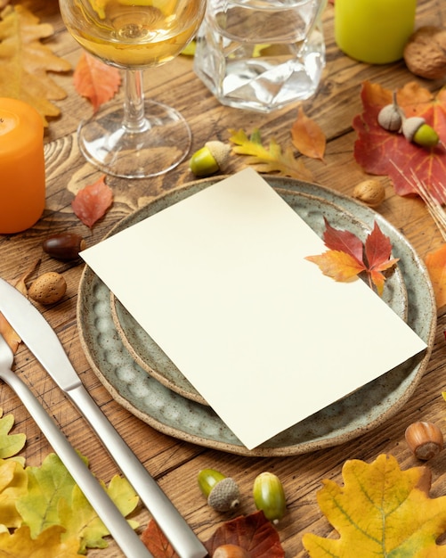 Cadre de table rustique d'automne avec carte vierge entre les feuilles et les baies close up mockup