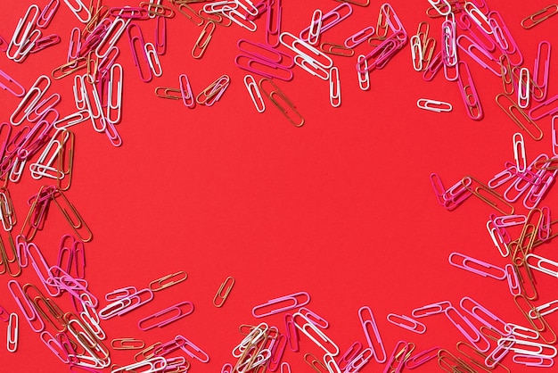 Cadre de trombones multicolores sur fond rouge Retour à l'école Concept d'éducation de la paperasserie d'affaires de bureau Bannière