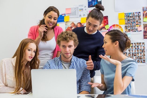 Cadres discutant sur un ordinateur portable au bureau