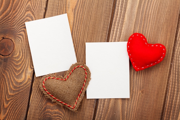 Cadres photo et coeurs de jouet de saint valentin faits à la main sur fond de bois