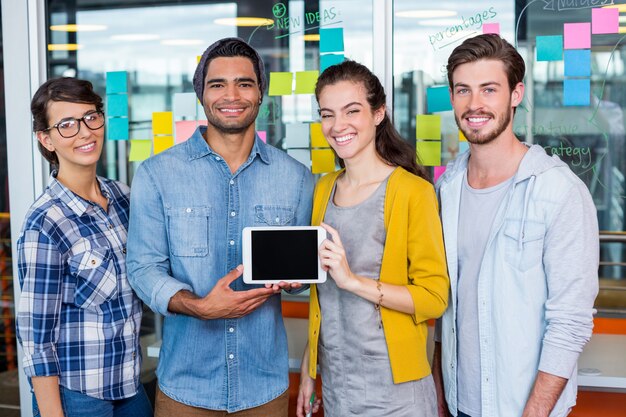 Cadres souriants discutant sur tablette numérique au bureau