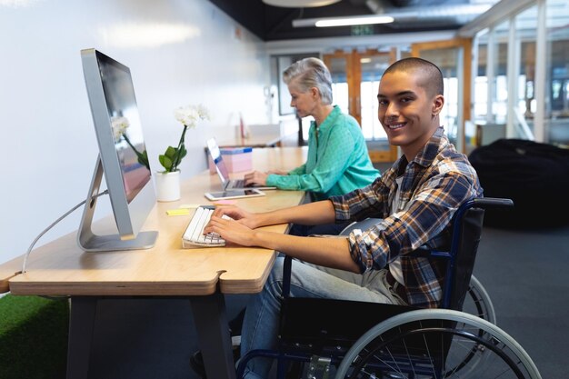 Photo des cadres travaillant sur un ordinateur et un ordinateur portable à leur bureau