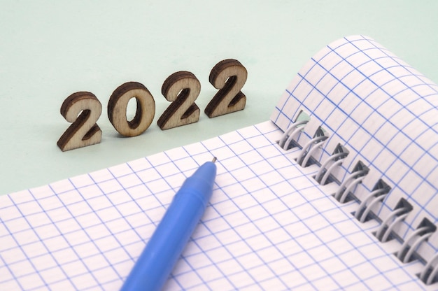 Cadret et stylo sur la table une feuille de papier blanche et un stylo à bille chiffres en bois 2022