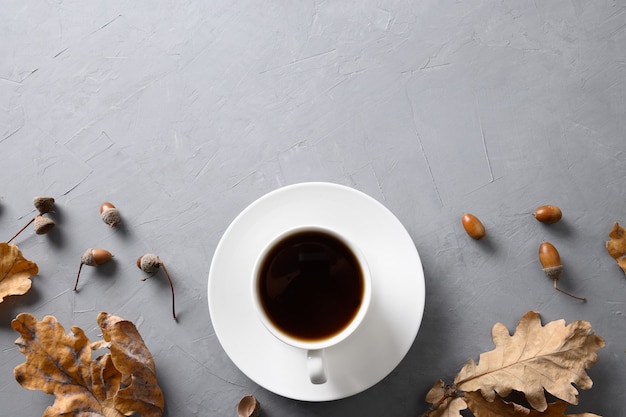 Café Acorn avec feuilles de chêne sur table en béton gris