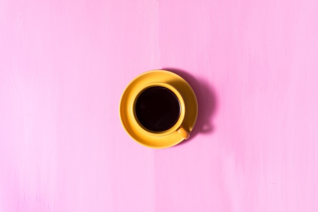 Café américain aromatique noir chaud sur une vieille table rose en bois. Conception avec espace copie Café chaud du matin.