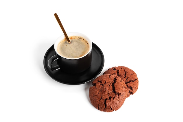 Café americano en tasse et soucoupe isolé sur fond blanc. Café chaud avec mousse. Café avec biscuit au chocolat. Photo de haute qualité