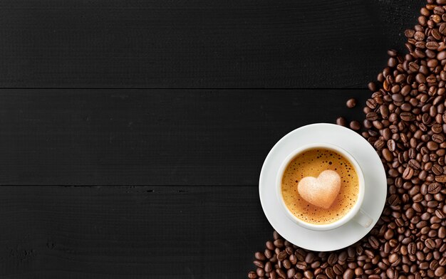 Café amour, art latte avec motif coeur dans une tasse blanche sur bois