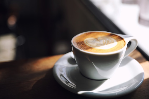 Café d'art Cappuccino ou Latte à base de lait sur la table en bois dans un café