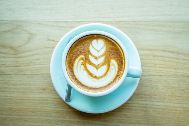 Café au lait chaud avec mousse de lait latte art dans une tasse tasse sur un bureau en bois sur la vue de dessus Comme petit-déjeuner Dans un café au concept de travail d'entreprise cafeduring