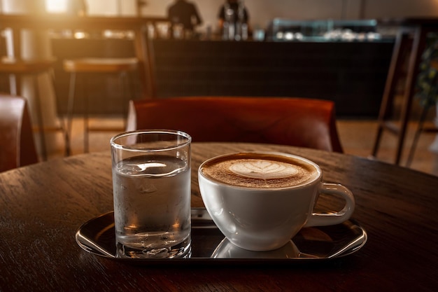 Café au lait chaud avec mousse de lait latte art dans une tasse tasse sur un bureau en bois sur la vue de dessus Comme petit-déjeuner Dans un café au concept de travail d'entreprise cafeduring