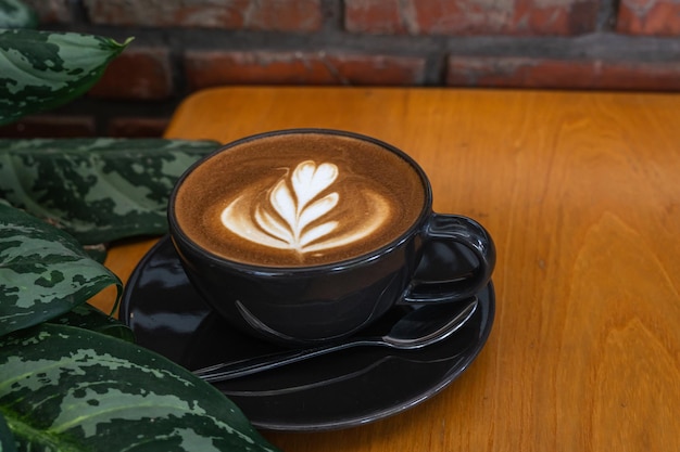 Café au lait chaud avec mousse de lait latte art dans une tasse tasse sur un bureau en bois sur la vue de dessus Comme petit-déjeuner Dans un café au concept de travail d'entreprise cafeduring