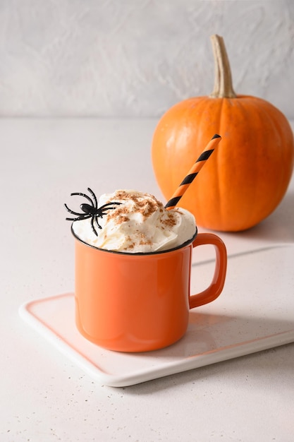 Café au lait de citrouille d'Halloween avec des araignées décorées de crème fouettée