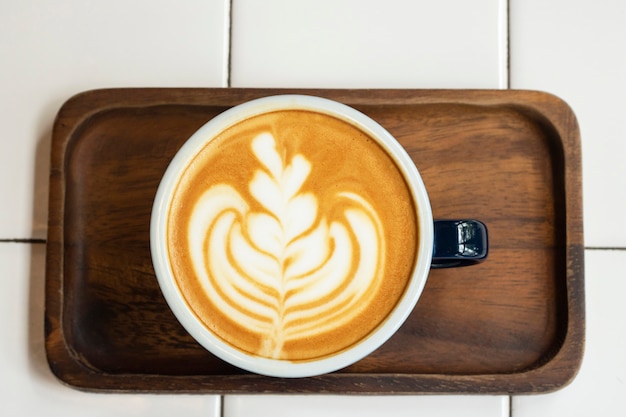 Café au lait dans une tasse sur un plateau en bois