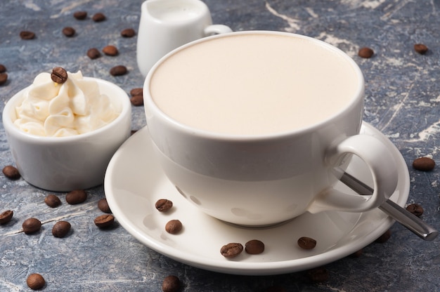 Café au lait et fromage à la crème sur fond gris avec des grains de café