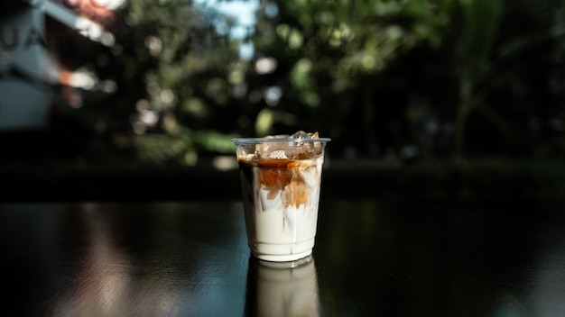 Café au lait glacé en verre plastique sur tableau noir