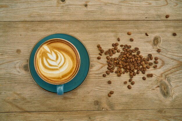 Café au lait et grains de café sur la table en bois