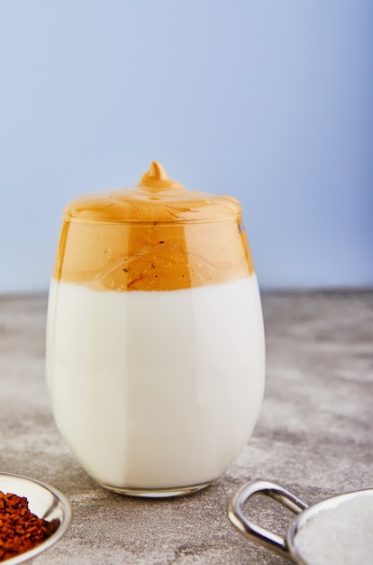 Café au lait avec mousse de café en verre haut et lait