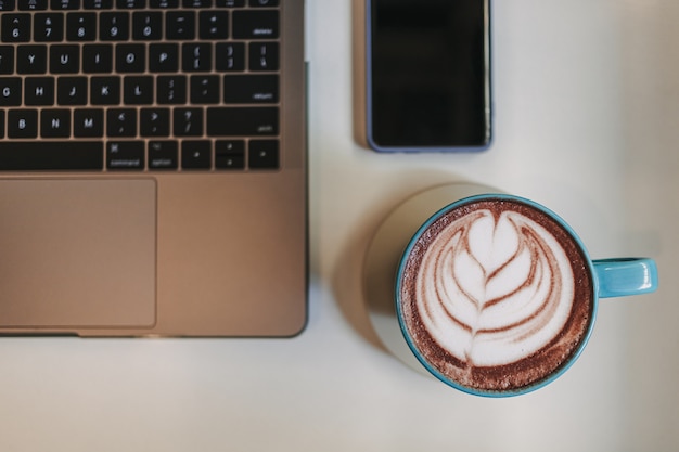 Café au lait avec ordinateur portable et téléphone portable