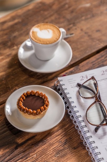 Café au lait près du gâteau et des verres