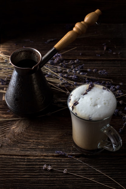 Café au lait ou raf de lavande avec des brindilles de lavande sur le fond. Style sombre et morose