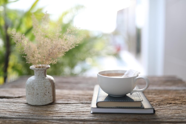 Café blanc et cahiers sur table en bois