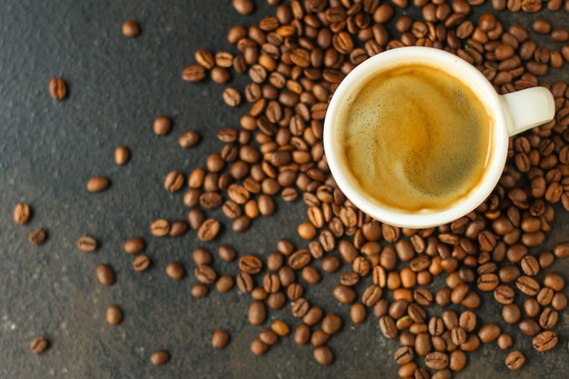 café boire dans une tasse blanche et saupoudrer de grains de café sur la table