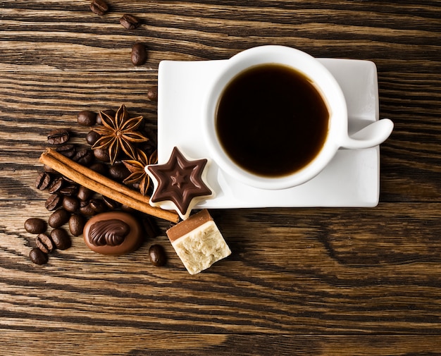 café, bonbons et épices sur une vieille table en bois