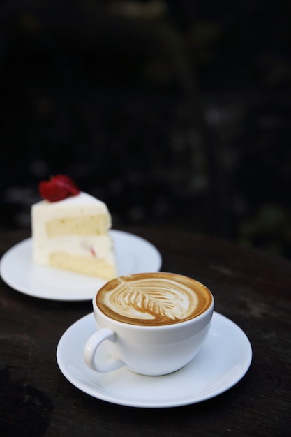 Café cappuccino avec gâteau sur bois