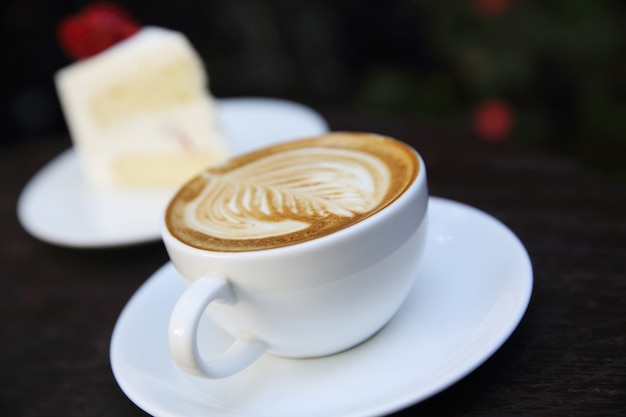 Café cappuccino avec gâteau sur fond de bois