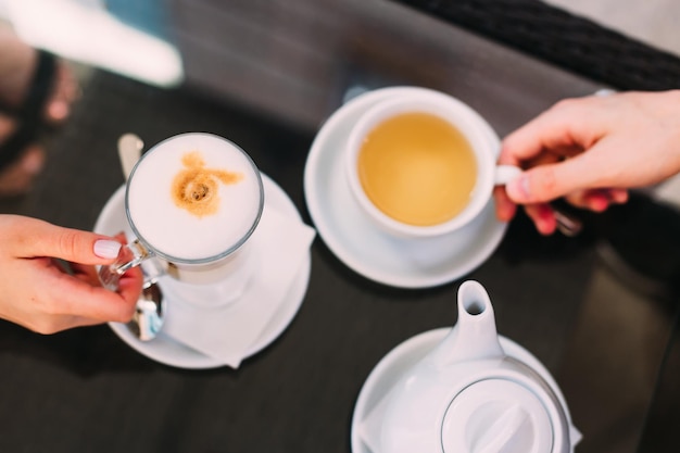 Café et cappuccino sur la table main de femme et homme café