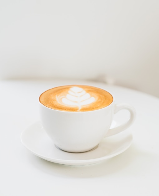 Café chaud avec art Latte et mug blanc sur fond blanc