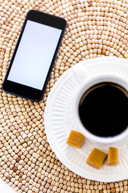 Café chaud avec des bonbons au caramel sur la table.