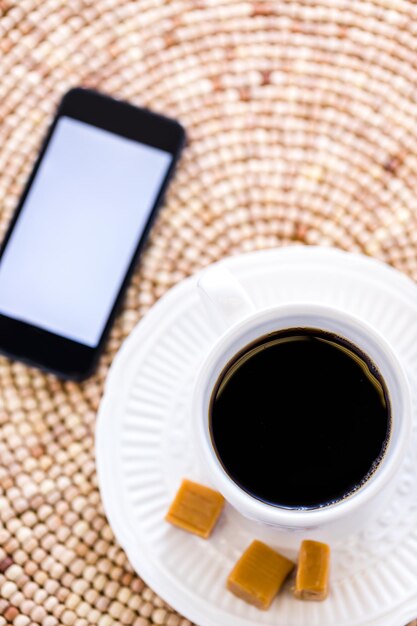 Café chaud avec des bonbons au caramel sur la table.